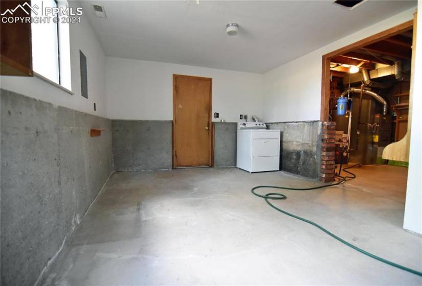 Unfinished basement with washer and dryer.  Walks out to garage and to back yard.
