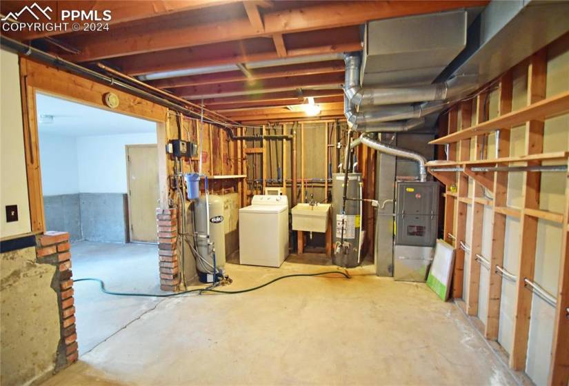 Basement featuring utility sink, washer & dryer, furnace and water heater
