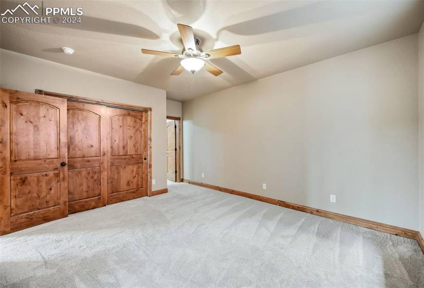 Unfurnished bedroom featuring carpet flooring and ceiling fan