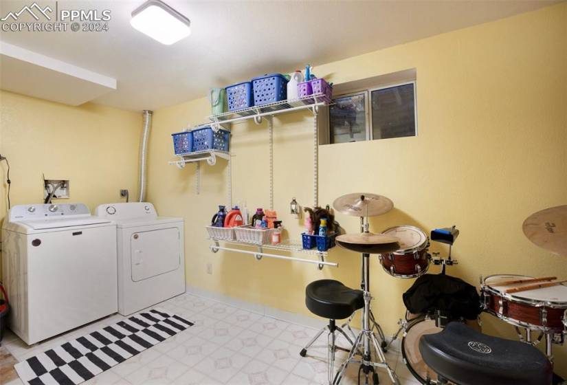 Clothes washing area featuring light tile floors, hookup for an electric dryer, and washer and dryer