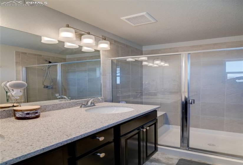 Bathroom with oversized vanity and a shower with shower door