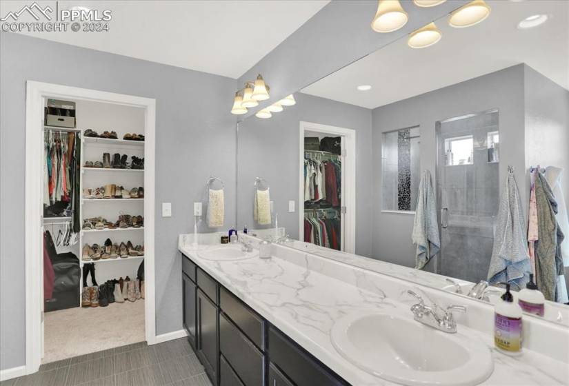 Bathroom featuring tile flooring, dual bowl vanity, and walk in shower