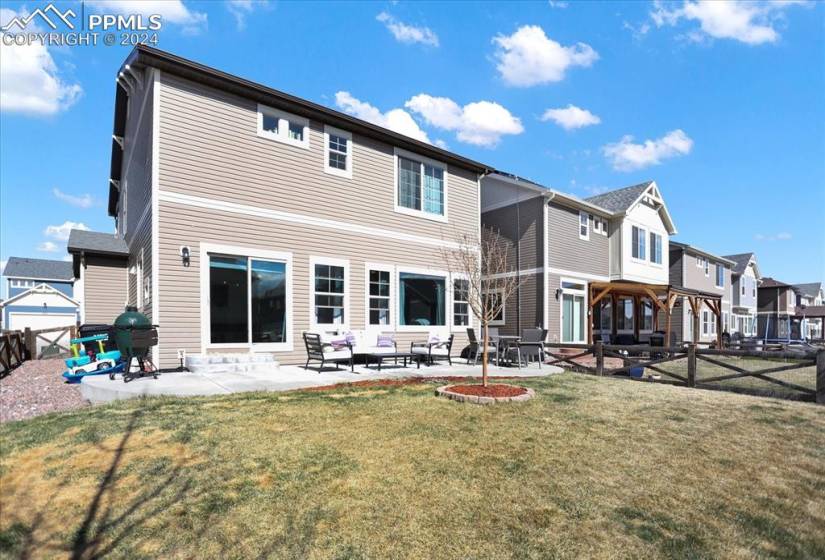 Rear view of property featuring a patio, a yard, and an outdoor living space