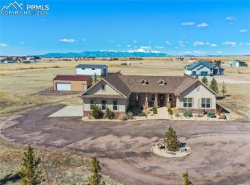 Custom Built Ranch Home sits on a 5.06-acre lot, offering stunning views of Pikes Peak + the Mountain Range blending luxury living w/the tranquility of a peaceful country setting