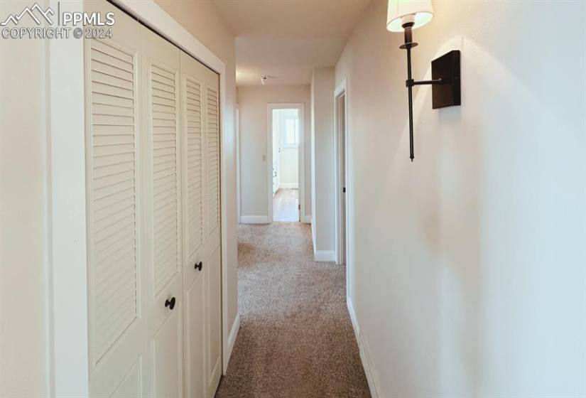 Corridor featuring light carpet