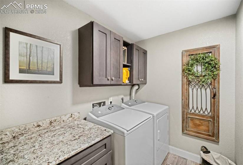 Fully Renovated Laundry Room with Cabinetry and Stone Counters