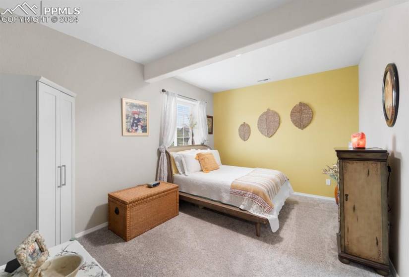 Carpeted bedroom featuring beamed ceiling