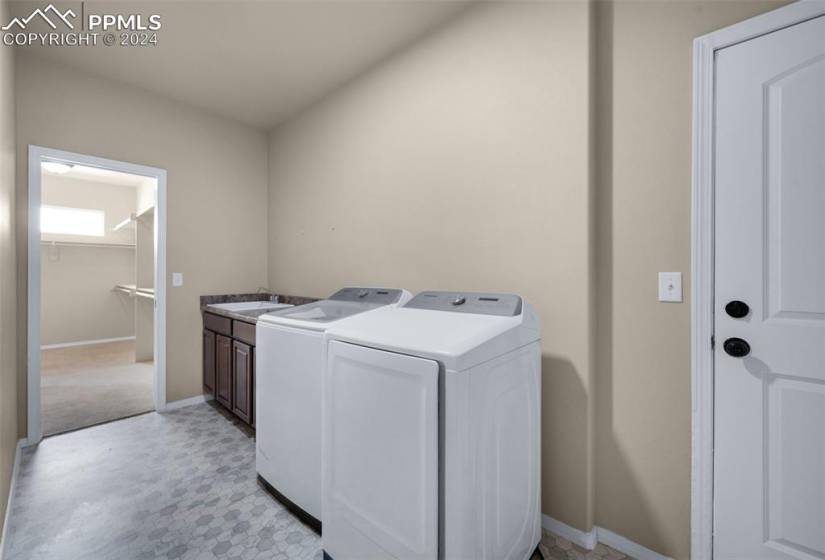 Laundry area with cabinets, independent washer and dryer, and sink