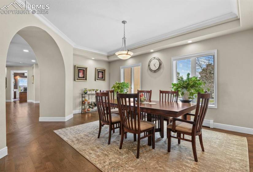 Dining room with dark hardwood / wood-style floors and a tray ceiling