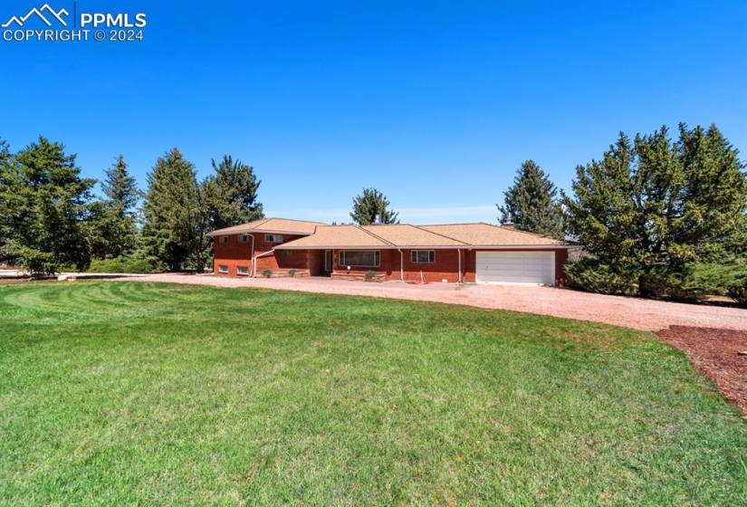 View of front of home with a garage and a front lawn