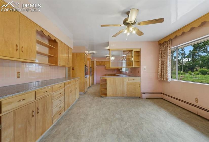 Kitchen with sink, tasteful backsplash, light brown cabinetry, and ceiling fan