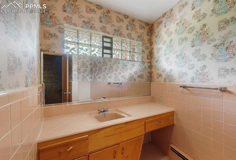 Bathroom featuring large vanity and tile walls