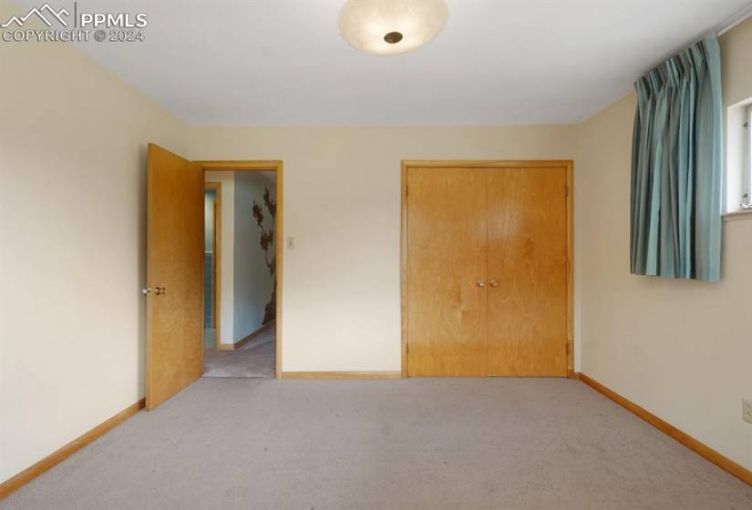 Unfurnished bedroom with a closet and light carpet