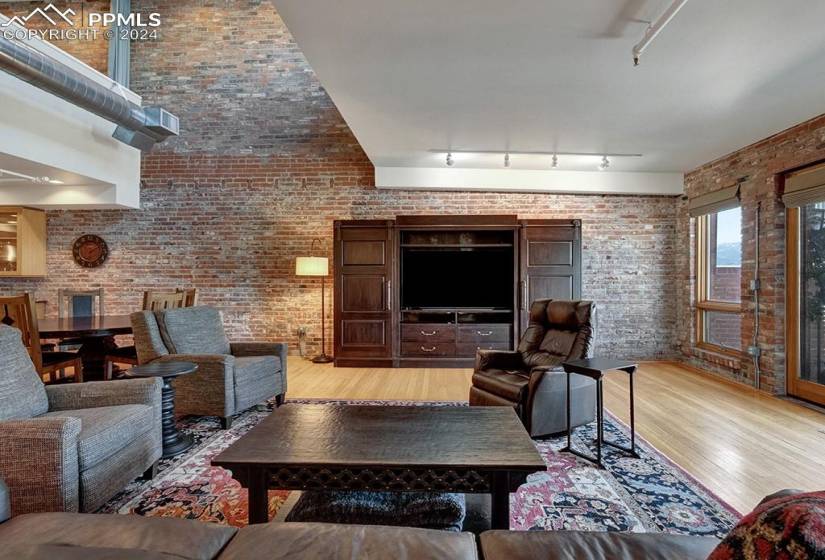 Living room with brick wall, track lighting above the gas fireplace.