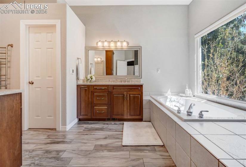 Bathroom with vanity and tiled tub