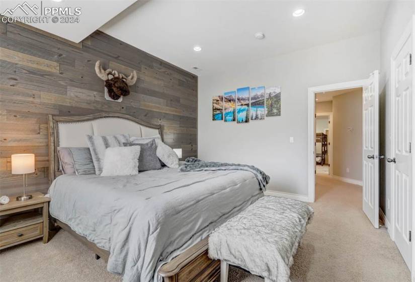 Carpeted bedroom with wood walls