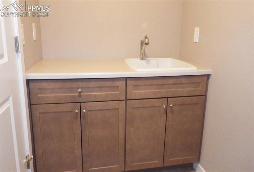 2nd floor laundry room with cabinets and sink