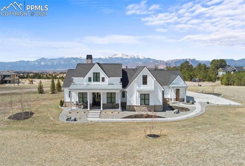 View of front facade with a mountain view, a front lawn, and a porch