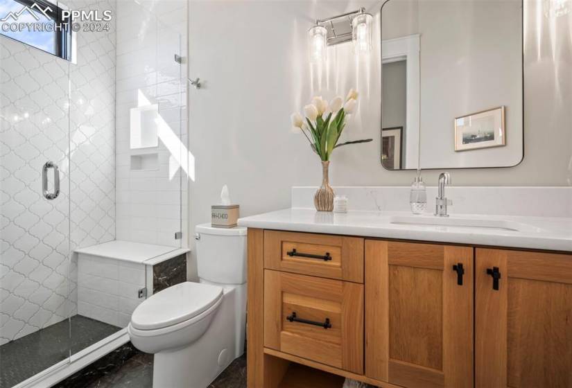 Bathroom featuring vanity, toilet, and a shower with shower door