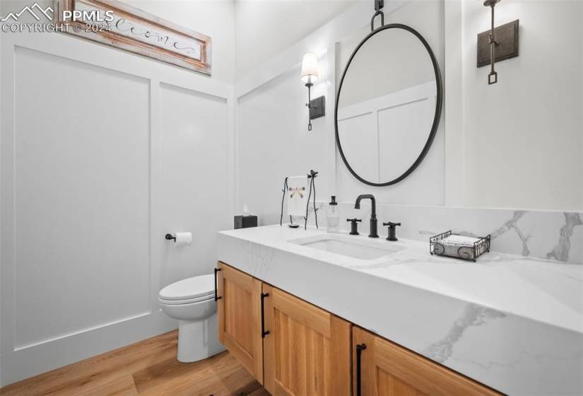 Bathroom featuring vanity, hardwood / wood-style flooring, and toilet