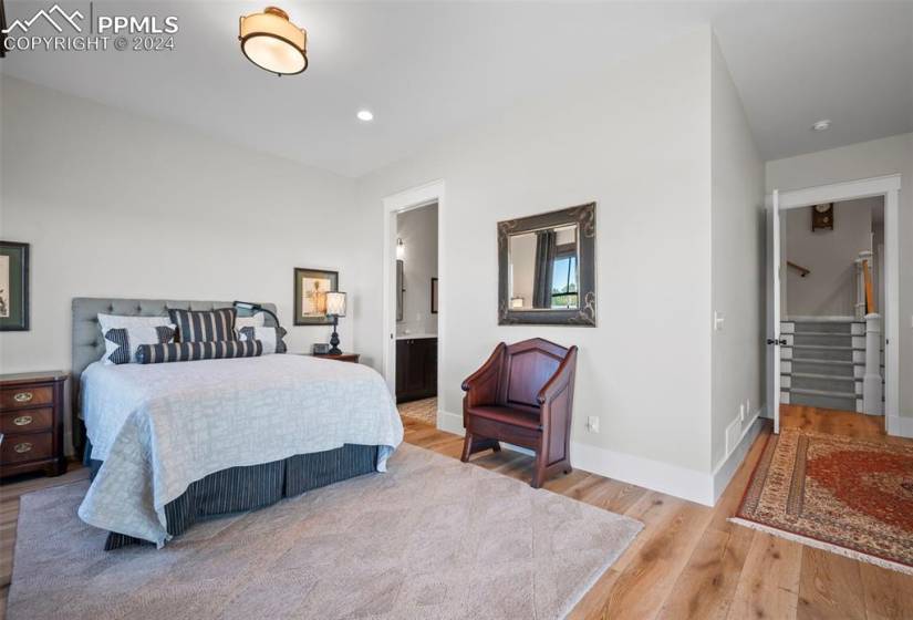 Bedroom featuring connected bathroom and light hardwood / wood-style floors, walkout