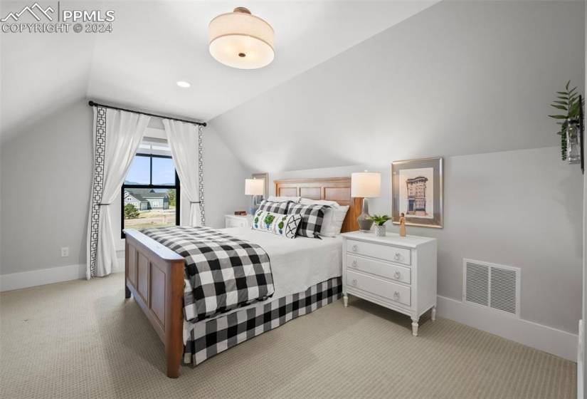 Carpeted bedroom with lofted ceiling