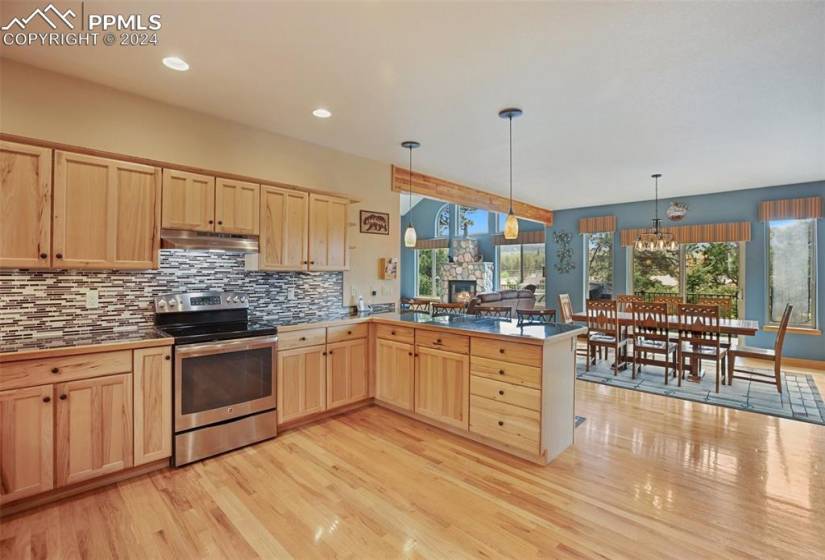 Kitchen featuring stainless steel electric range oven, plenty of natural light, and light hardwood / wood-style flooring
