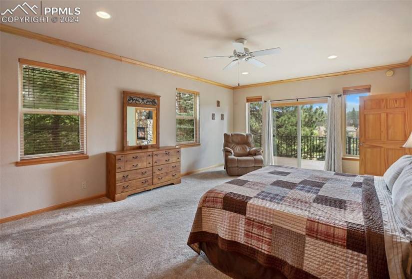 Carpeted bedroom featuring ceiling fan, crown molding, and access to outside