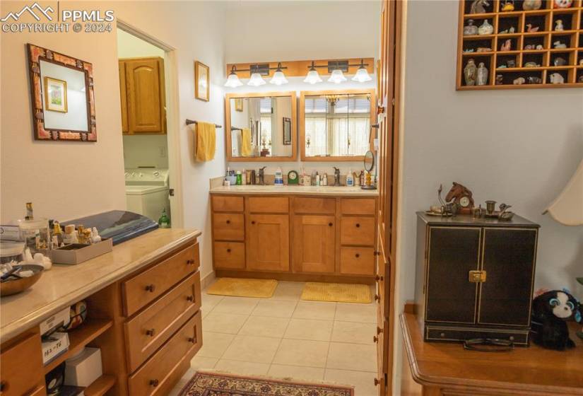 Bathroom with independent washer and dryer, oversized vanity, and tile floors