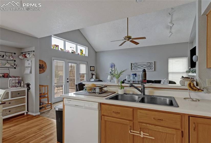 Kitchen with sink, dishwasher, ceiling fan, and a textured ceiling