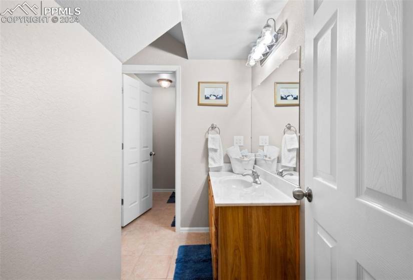 Bathroom featuring vanity with extensive cabinet space and tile floors