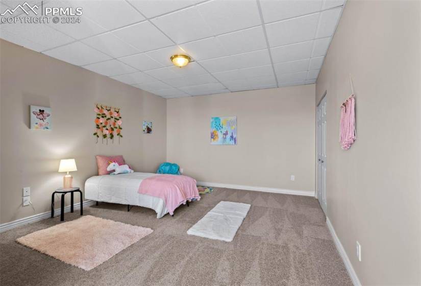 Bedroom with a drop ceiling and carpet floors