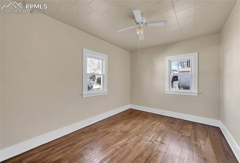 Empty room with hardwood / wood-style floors and ceiling fan