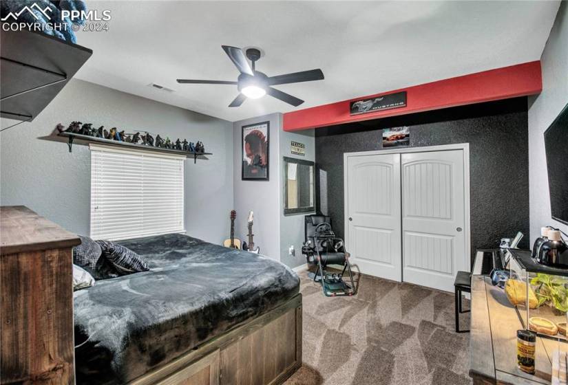 Bedroom featuring a closet, dark carpet, and ceiling fan