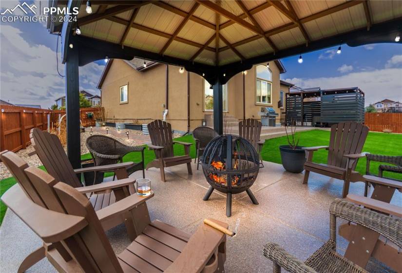 View of patio featuring grilling area, a fire pit, and a gazebo