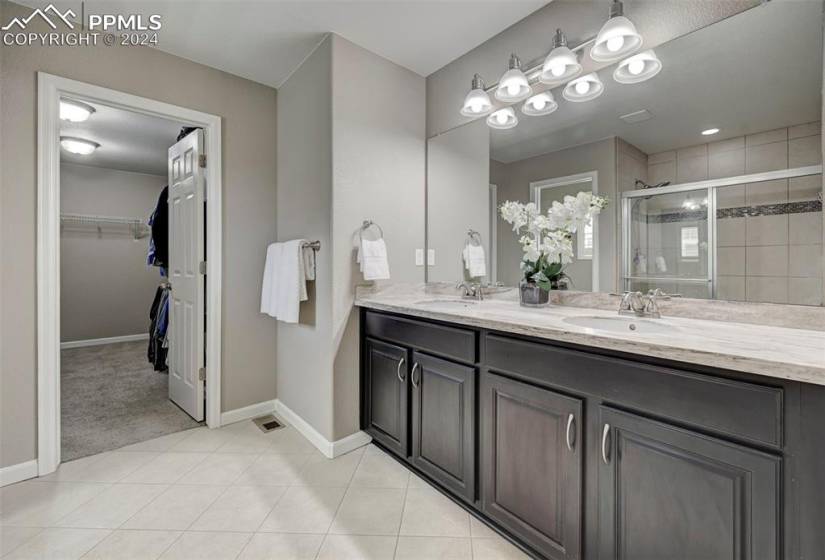 Bathroom featuring dual sinks, oversized vanity, and tile floors