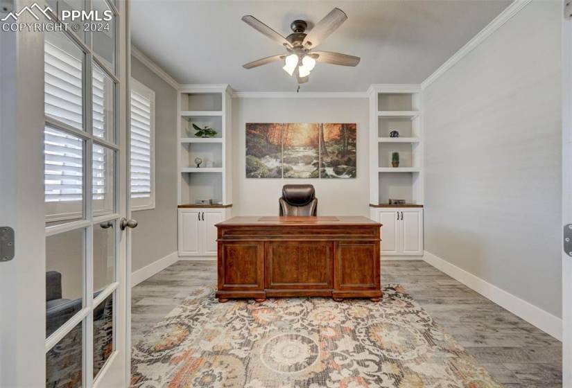 Office space with ornamental molding, light hardwood / wood-style flooring, and ceiling fan