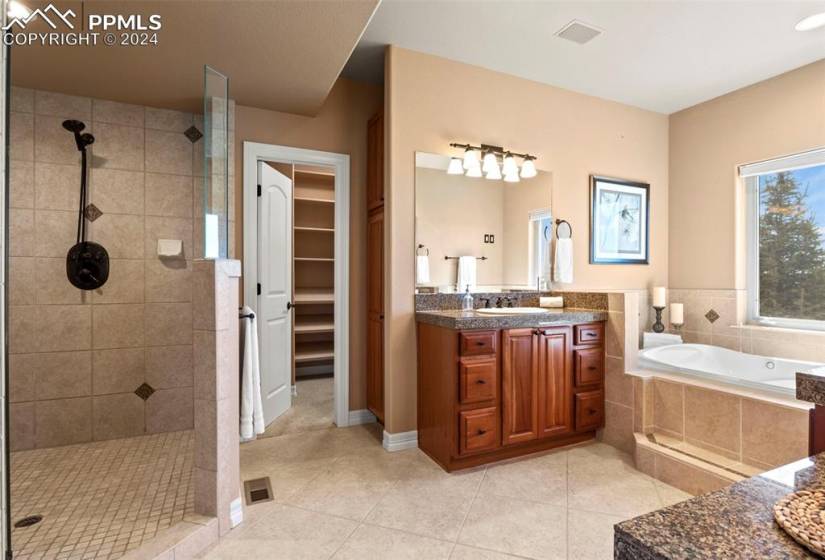 Bathroom featuring tile flooring, 2 sinks, and a walk in shower