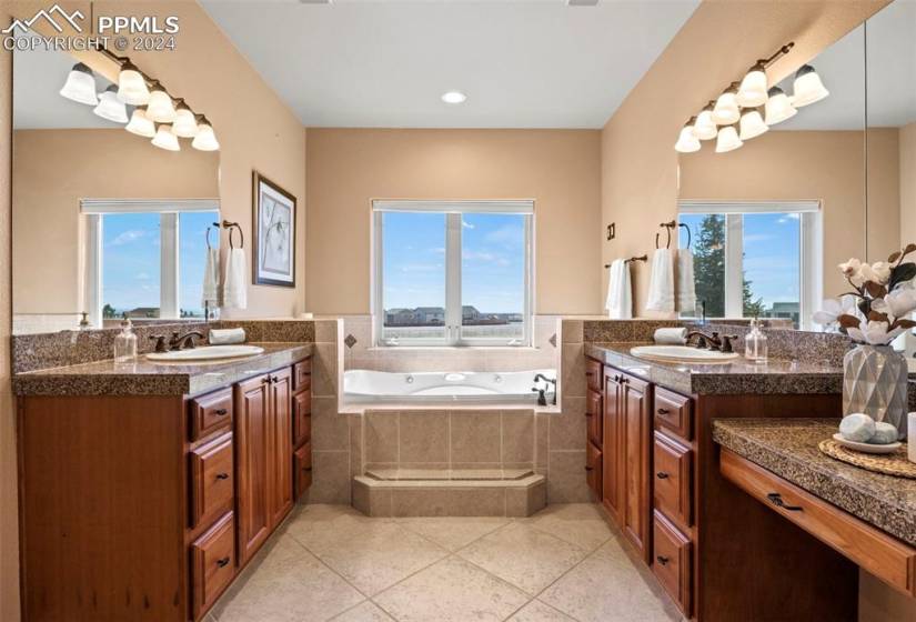 Master bath has a healthy amount of sunlight, tile floors, and tiled jetted bath