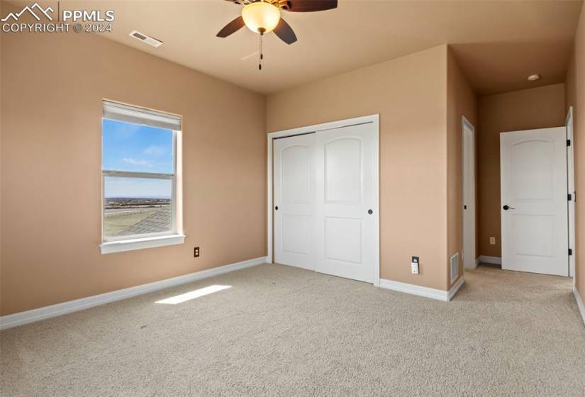 Upper bedroom with ceiling fan, and access to attached bath.