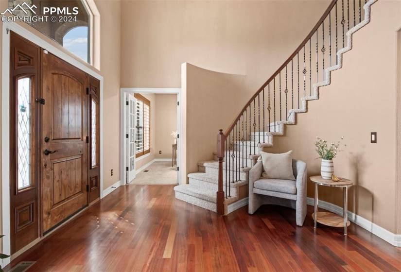 Entryway featuring cherry wood flooring and a high ceiling.