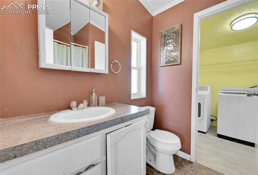 Bathroom featuring tile floors, a textured ceiling, vanity, and toilet