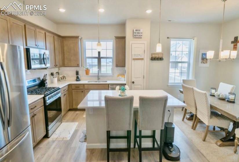 Kitchen featuring appliances with stainless steel finishes, light hardwood / wood-style flooring, sink, and plenty of natural light