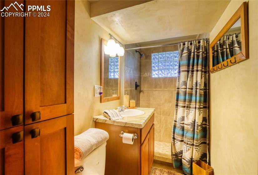Bathroom featuring vanity, tile walls, toilet, and a shower with shower curtain