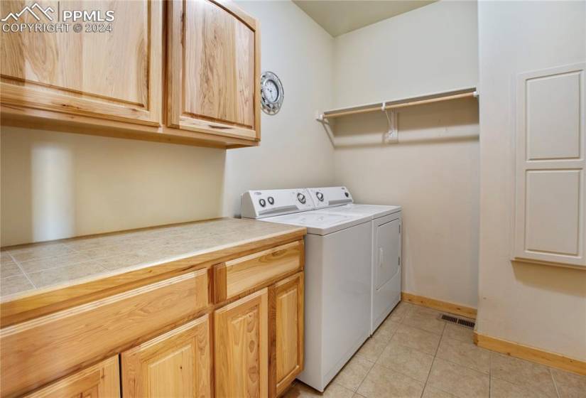 Main level laundry featuring independent washer and dryer, tile flooring, and built-in cabinets