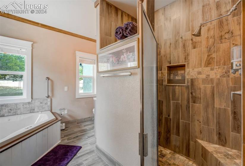 Bathroom featuring hardwood / wood-style floors, independent shower and bath, and crown molding