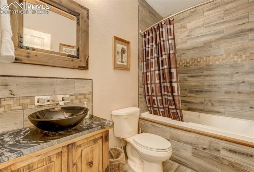 Full bathroom featuring shower / tub combo with curtain, vanity, and toilet