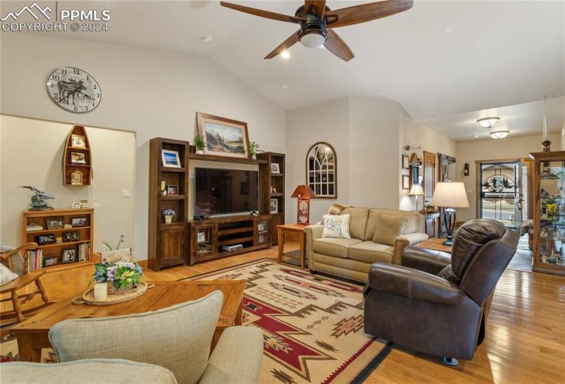 Family room with vaulted ceiling, light hardwood / wood-style floors, and ceiling fan