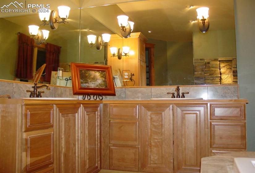Bathroom featuring backsplash, a chandelier, dual vanity, and a bathing tub