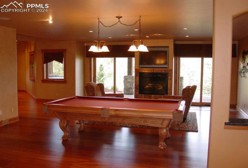 Recreation room featuring dark hardwood / wood-style flooring, a tile fireplace, and pool table